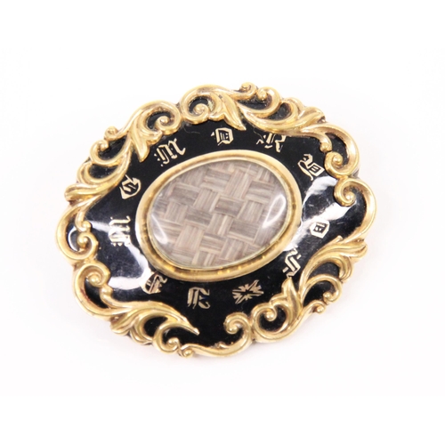 177 - A late 19th century style black enamel mourning brooch, the oval brooch with scrolling foliate yello... 