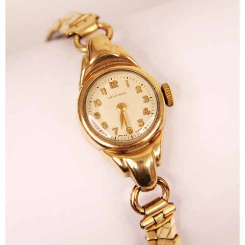 79 - A yellow metal ladies Longines wristwatch, the circular champagne coloured dial with Roman numerals,... 