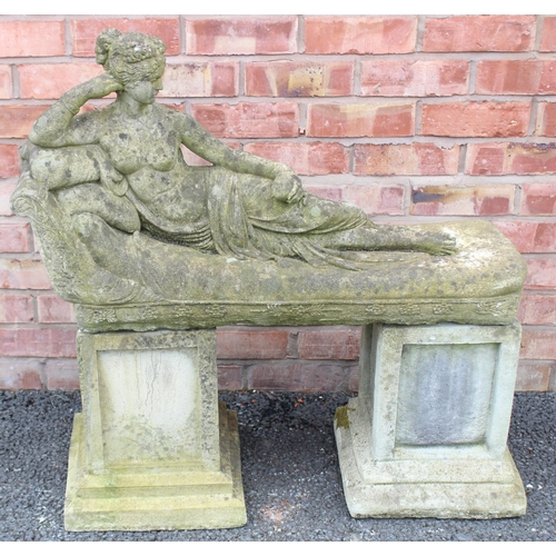 803 - A reconstituted stone garden ornament modelled as a classical female reclining figure upon a couch, ... 