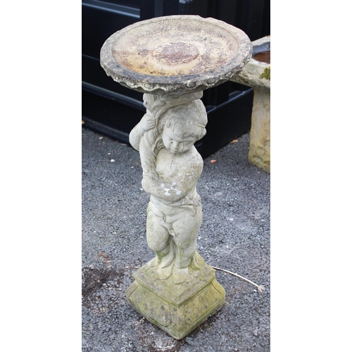 801 - A reconstituted stone figural bird bath, the shallow well upon a figural pedestal modelled as a youn... 