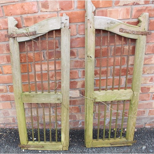 815 - A pair of hardwood and wrought iron gates, applied with iron ring hinges, each gate measures, 106cm ... 