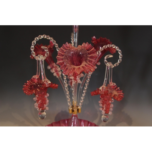 495 - A cranberry glass epergne of typical form, with central trumpet over three lower trumpets, and three... 