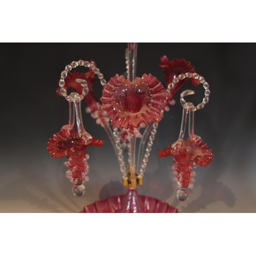 495 - A cranberry glass epergne of typical form, with central trumpet over three lower trumpets, and three... 