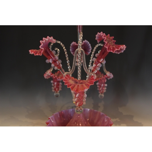 499 - A cranberry glass epergne of typical form, with central trumpet over three lower trumpets, and three... 