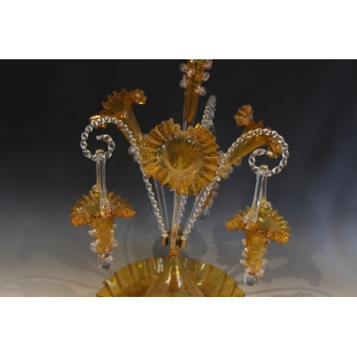 501 - A yellow glass epergne of typical form, with central trumpet over three lower trumpets, and three ca... 