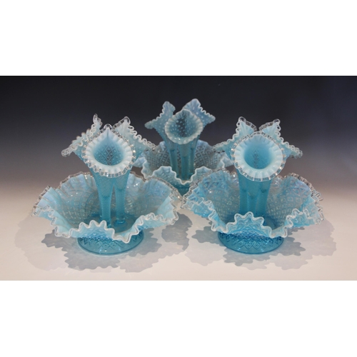 504 - A near pair of powder blue vaseline glass epergnes, each with three trumpets, crimped rims, and moul... 