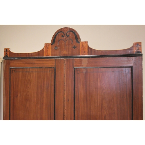 730 - A late George III mahogany wardrobe, possibly Channel Islands, the arched cornice inlaid with stylis... 