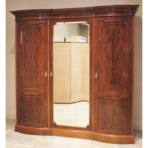 791 - An Edwardian mahogany inlaid triple wardrobe, by Warings, of inverted breakfront form, the central m... 