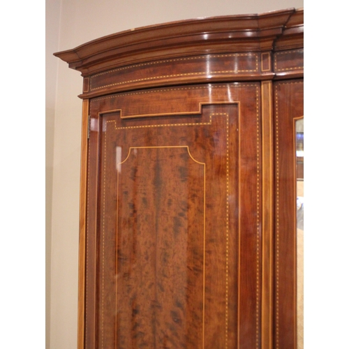 791 - An Edwardian mahogany inlaid triple wardrobe, by Warings, of inverted breakfront form, the central m... 