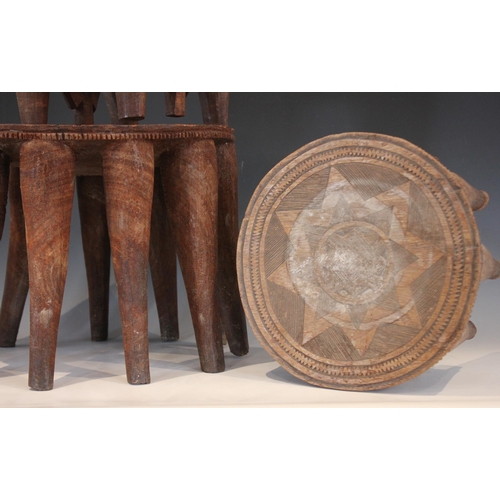 629 - Two Nigerian Nupe Tribe stools, each circular shaped top with carved geometric detailing, and raised... 