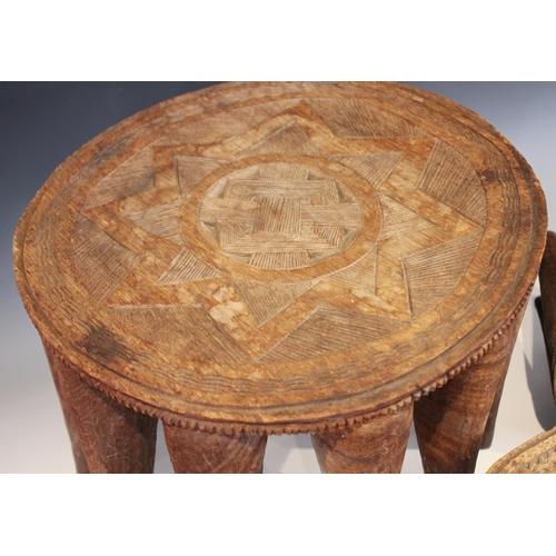 629 - Two Nigerian Nupe Tribe stools, each circular shaped top with carved geometric detailing, and raised... 