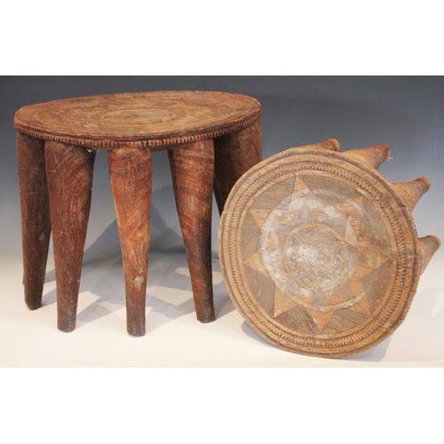 629 - Two Nigerian Nupe Tribe stools, each circular shaped top with carved geometric detailing, and raised... 