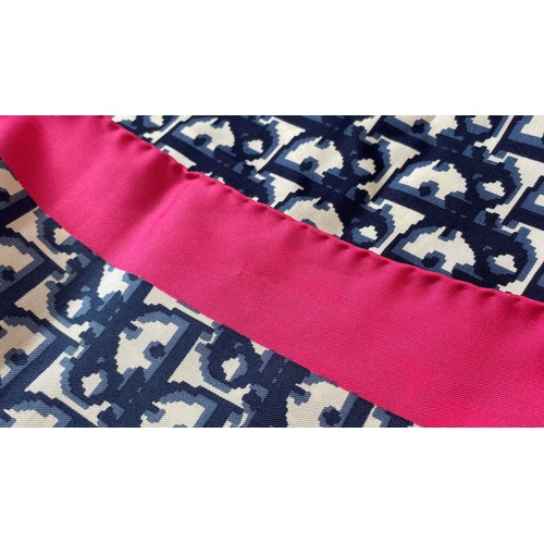 583 - A Christian Dior silk scarf, in navy monogram surrounded by a fuscia pink border, with rolled hem, 7... 