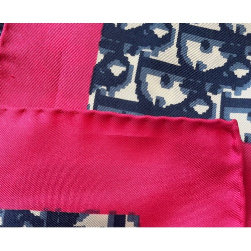 583 - A Christian Dior silk scarf, in navy monogram surrounded by a fuscia pink border, with rolled hem, 7... 