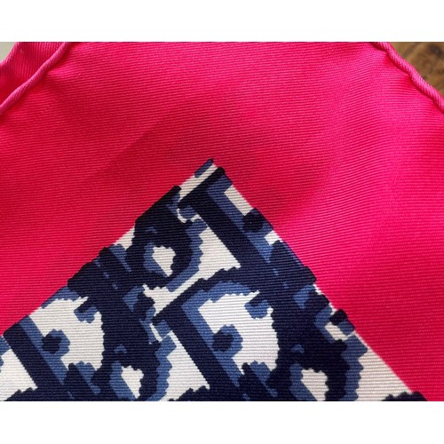 583 - A Christian Dior silk scarf, in navy monogram surrounded by a fuscia pink border, with rolled hem, 7... 