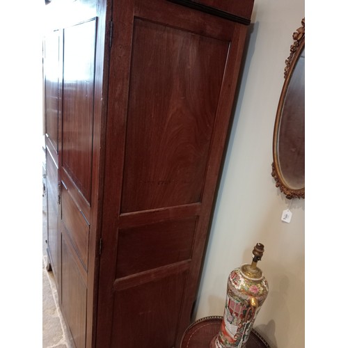 730 - A late George III mahogany wardrobe, possibly Channel Islands, the arched cornice inlaid with stylis... 