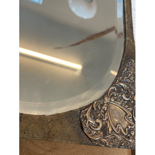 5 - An Edwardian silver mounted mirror, William Devenport, Birmingham 1902, the oval mirror with a surro... 