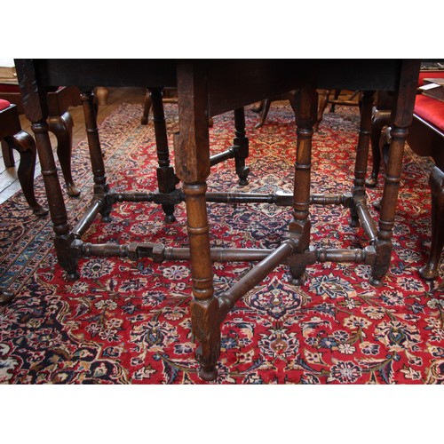 709 - A late 17th century oak gate leg table, the oval plank top above a single frieze drawer, upon ring t... 