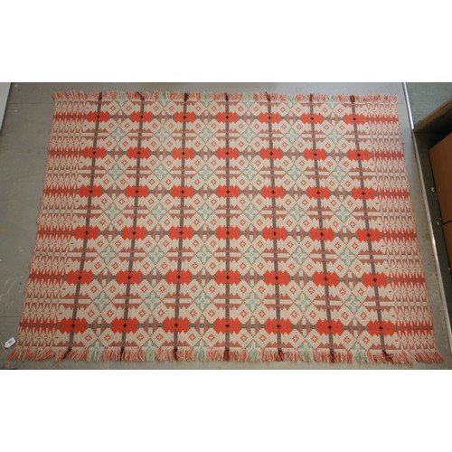 595 - A Welsh blanket of small proportions, the unusual reversible geometric design in pinks, corals and t... 