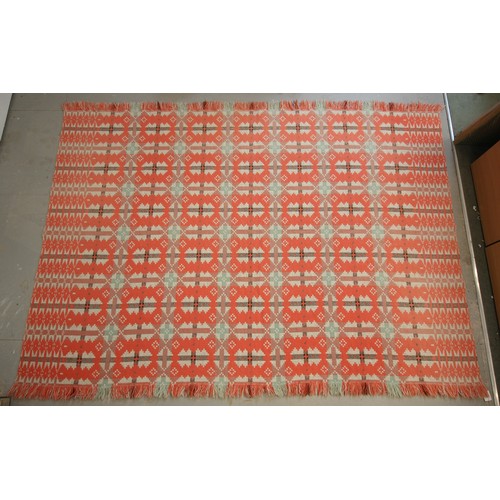 595 - A Welsh blanket of small proportions, the unusual reversible geometric design in pinks, corals and t... 