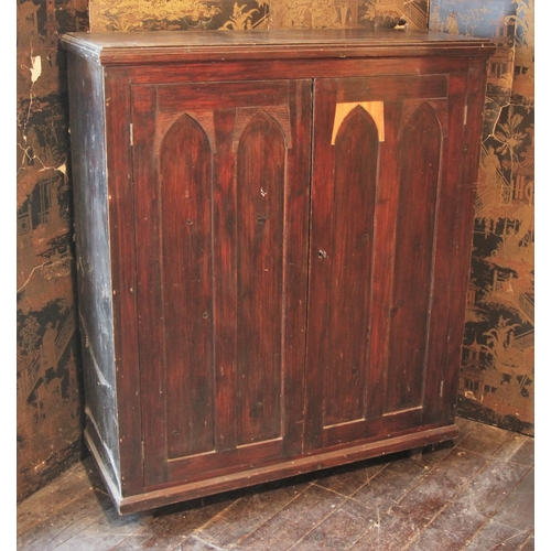 679 - * A Victorian ecclesiastical stained pine hall cupboard, the ogee panelled twin doors opening to thr... 