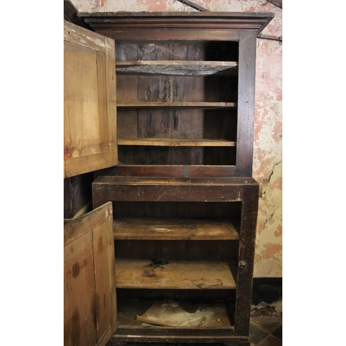 697 - * A 19th century stained pine pantry, the moulded cornice over two graduated cupboard doors, opening... 