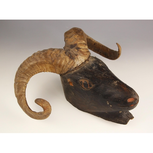 261 - TAXIDERMY: A pair of skull cap mounted ram's horns, set to a naively carved and ebonised wooden ram'... 