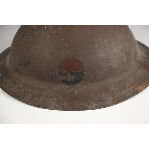 319 - WORLD WAR I/II INTEREST: A World War I British Brodie rimless combat helmet, first pattern, one side... 