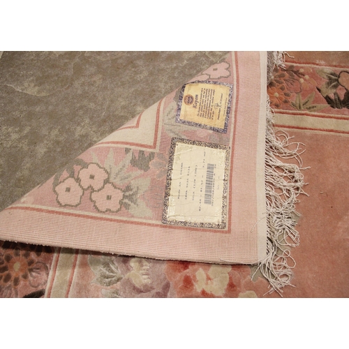 1053 - A Chinese Kayam silk pile rug, the pink ground with a mirrored floral design, within recurring borde... 