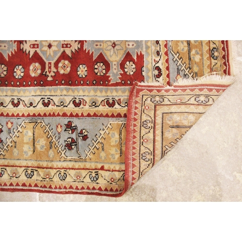 1055 - A Baluchistan wool rug, in red, sky blue and oatmeal colourways, the central red field with five rec... 