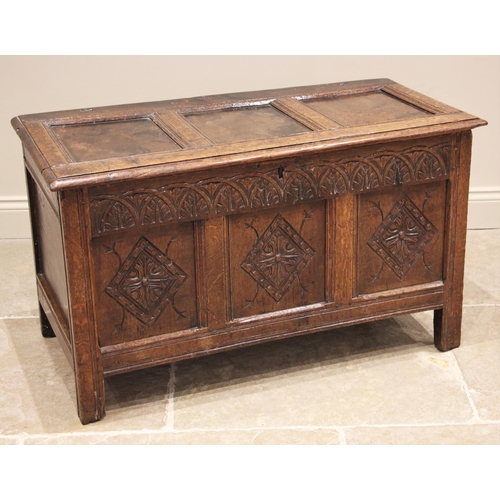 1093 - A carved oak coffer, late 17th/early 18th century, the three panel hinged top (detached), over a lun... 