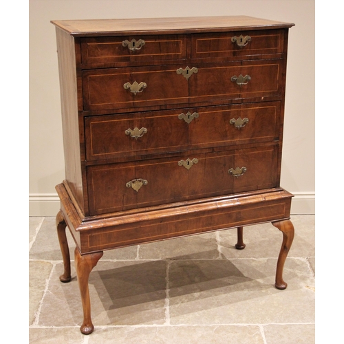 1097 - A George II walnut chest on stand, mid 18th century, the quarter veneered and crossbanded top over a... 