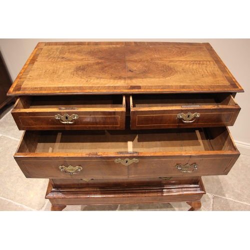 1097 - A George II walnut chest on stand, mid 18th century, the quarter veneered and crossbanded top over a... 