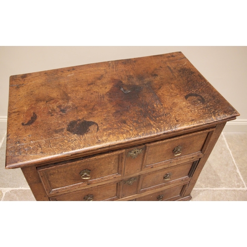 1101 - A Jacobean oak chest of drawers, the plank top above an arrangement of three elm lined long drawers,... 