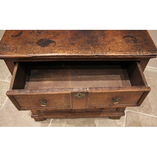 1101 - A Jacobean oak chest of drawers, the plank top above an arrangement of three elm lined long drawers,... 