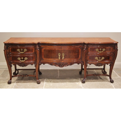 1162 - An Italian carved walnut sideboard, mid 20th century, the serpentine break-front above central cupbo... 