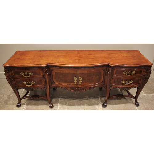 1162 - An Italian carved walnut sideboard, mid 20th century, the serpentine break-front above central cupbo... 