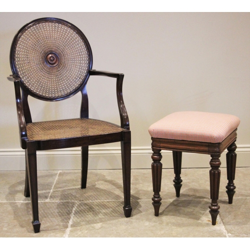 1182 - A mahogany bergere elbow chair, early 20th century, the circular cane work back rest centred with a ... 