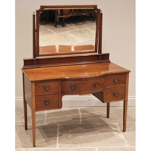 1202 - An Edwardian mahogany dressing table, of break-arch form, the bevelled mirror plate above an arrange... 