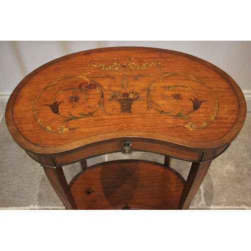 1207 - An Edwardian Sheraton revival kidney shaped occasional table, the banded top inlaid with a basket of... 