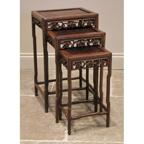 1210 - A nest of three Chinese rosewood tables, 20th century, of rectangular form, with a carved vinery ope... 