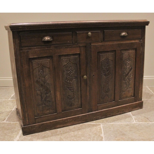 1214 - An Edwardian walnut side cupboard, the moulded top with a dentil frieze over three drawers and a pai... 