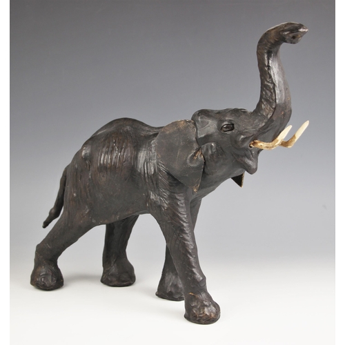 523 - A leather covered elephant, 20th century, modelled with trunk raised, leather ears (possibly  later)... 