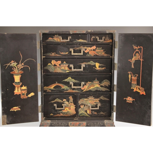 750 - A Japanese black lacquer kodansu, Meiji period, 1868-1912, applied in relief with pagoda landscapes,... 