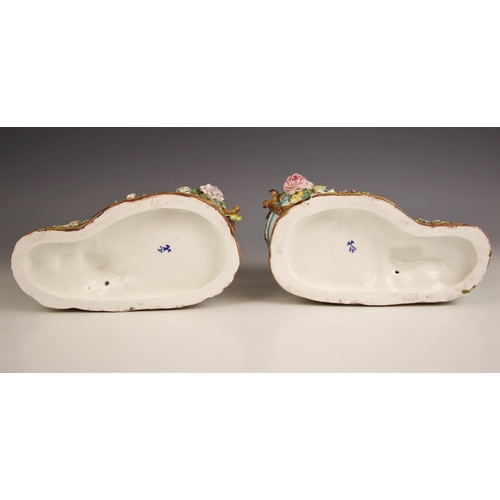 782 - A pair of continental porcelain florally encrusted figural potpourris, 19th century, one modelled as... 