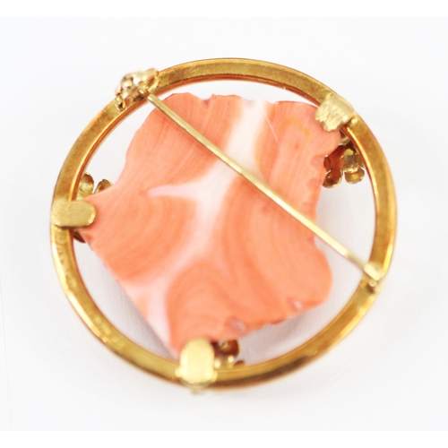 370 - An 18ct yellow gold and pink hardstone brooch, the central carved head of a maiden facing dexter wit... 