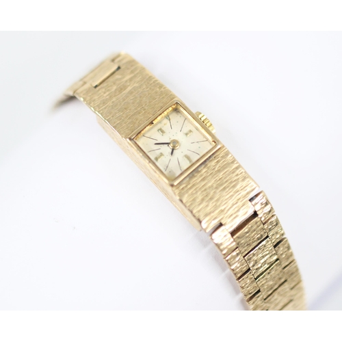 463 - A 9ct yellow gold ladies wristwatch, the square cream coloured dial with baton markers, set to a tex... 