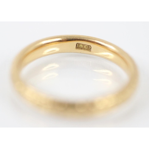 218 - A yellow metal engraved wedding band, designed with continuous foliate decoration, stamped '18ct' ri... 