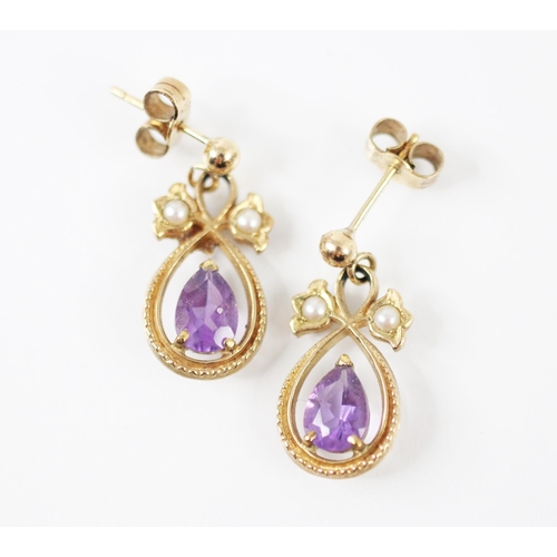 252 - A pair of yellow metal amethyst and seed pearl set drop earrings, the pear shaped amethyst within se... 