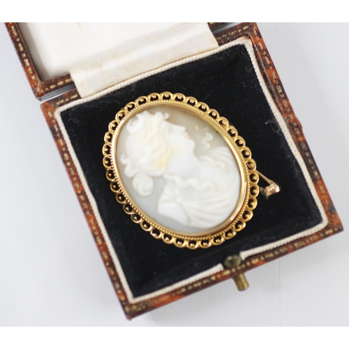 257 - A carved shell cameo brooch/pendant, the oval cameo depicting a classical maiden in profile, within ... 